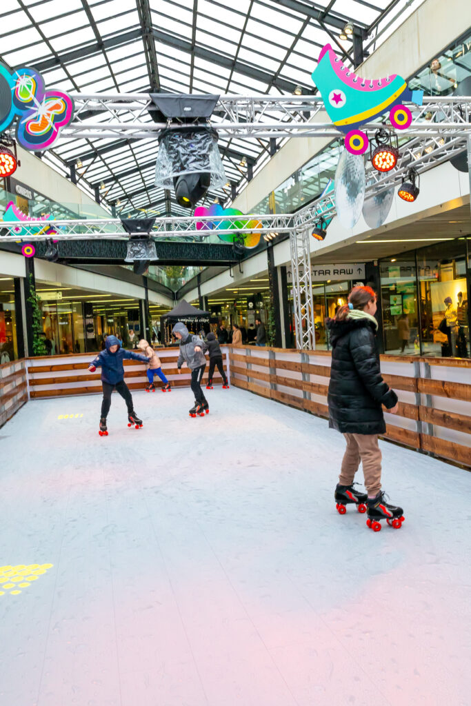 Patineuse sur la piste décorée de guirlandes colorées
