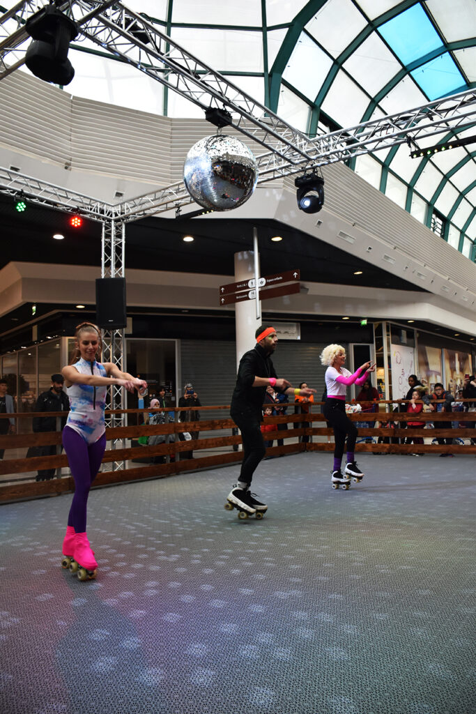 Patineuses sous la boule à facettes et les projecteurs