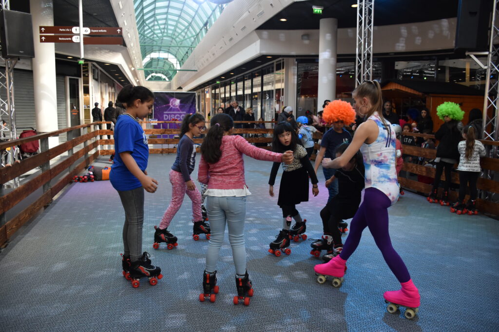 Enfants et adolescents patinant sur une piste roller disco en centre commercial