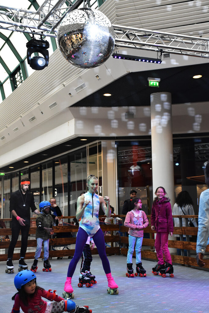 Patineurs sous la boule à facettes lors d'une animation roller disco