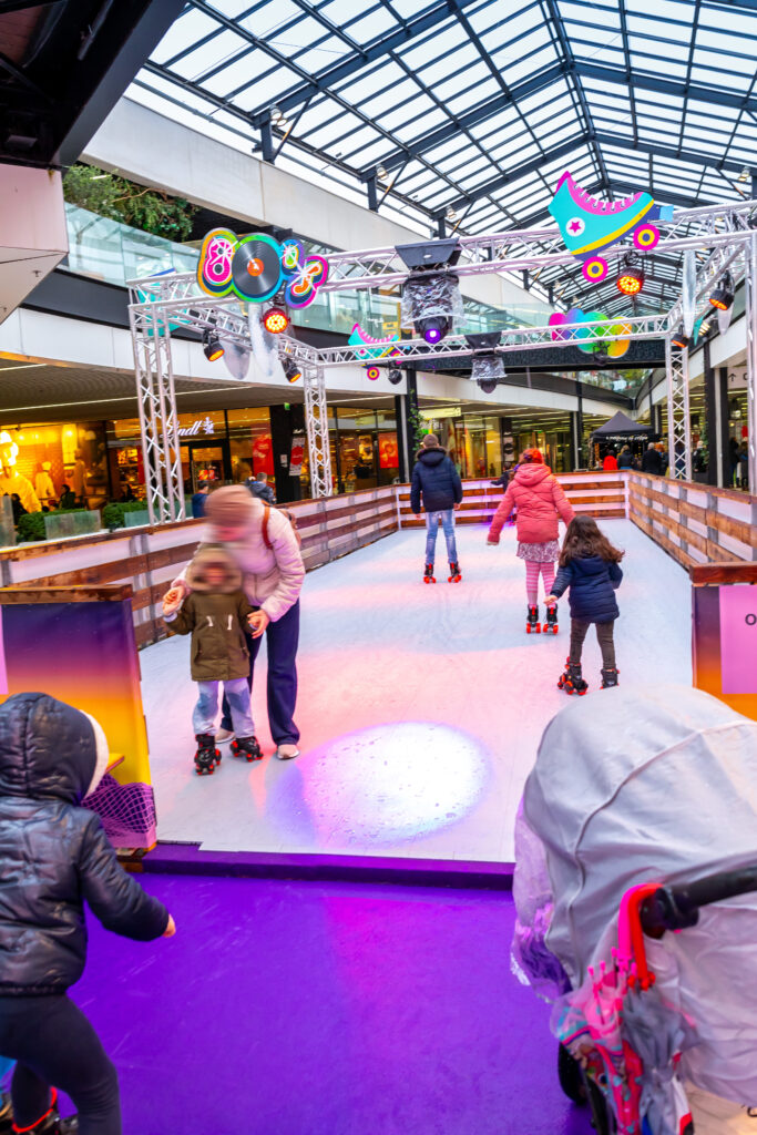 Familles et enfants patinant dans un centre commercial