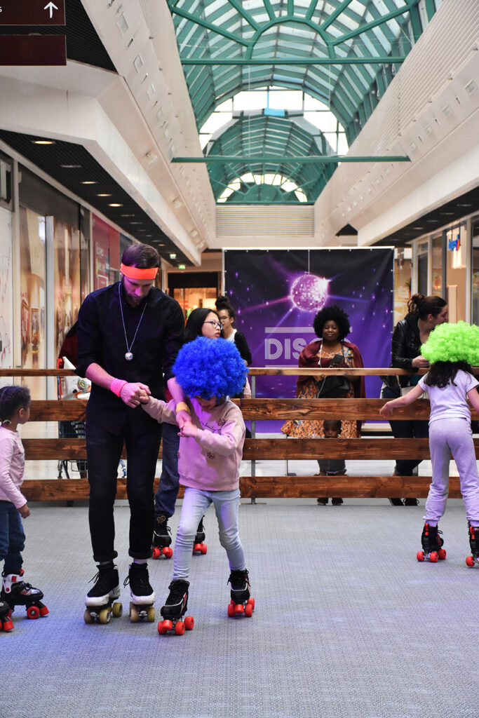 Coach roller disco accompagnant des enfants équipés de protections