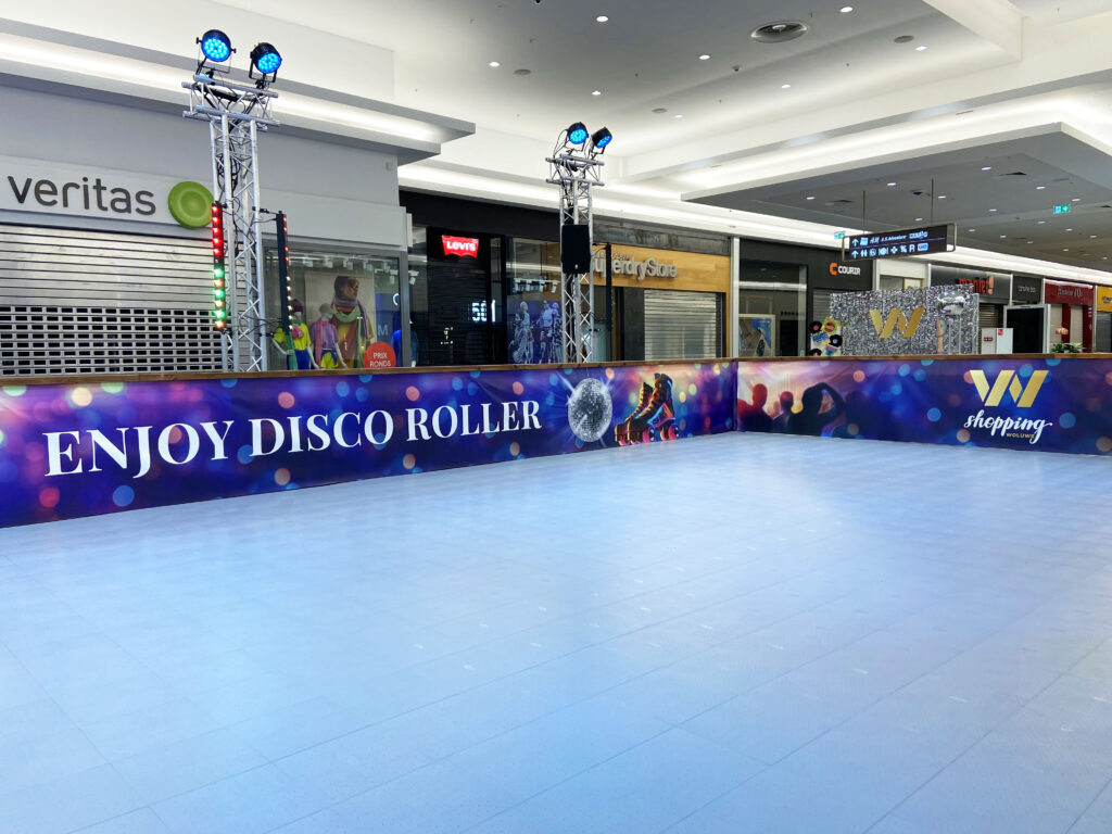 Piste roller disco habillée « Enjoy Disco Roller » dans une galerie commerciale